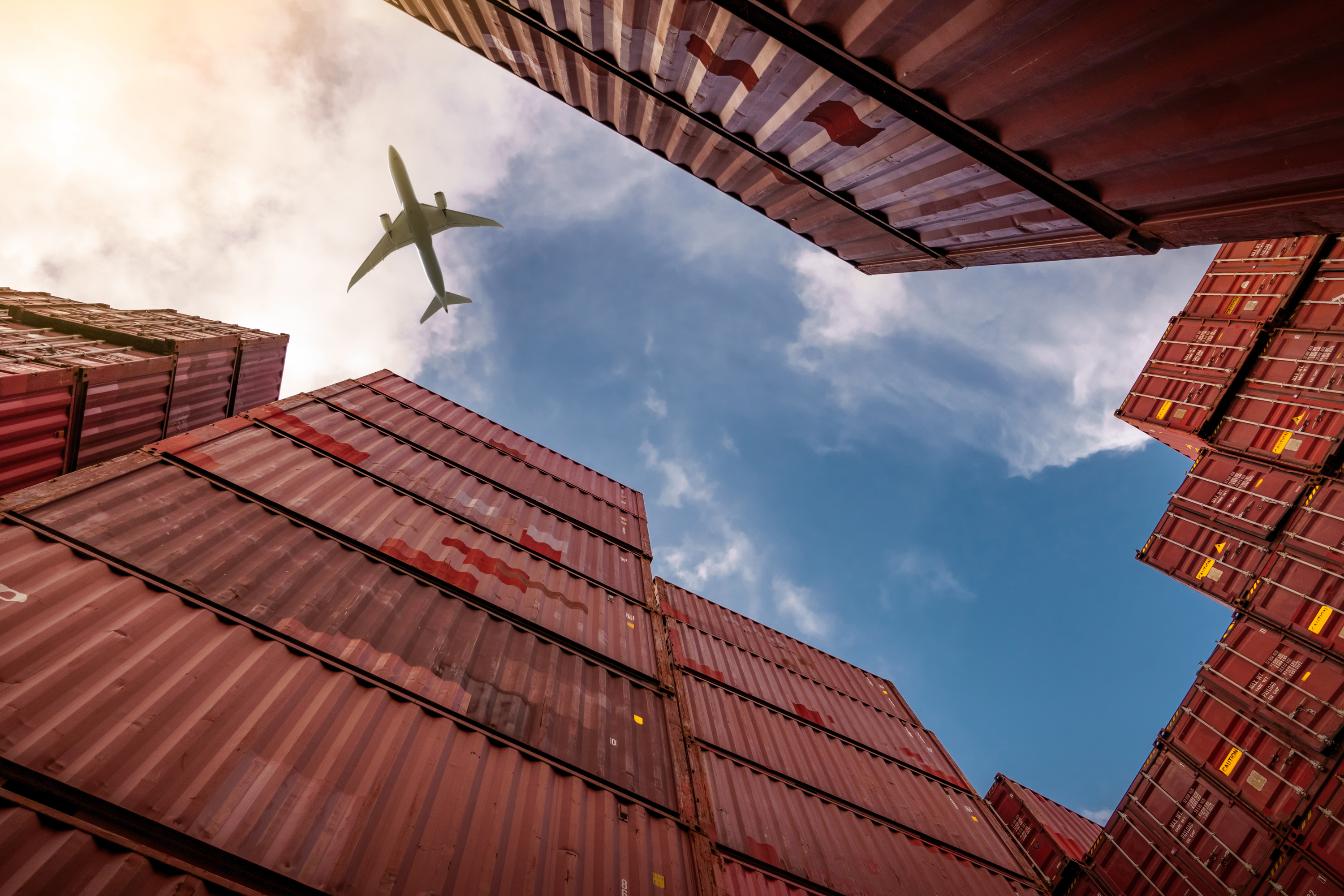 Airplane Flying Above Container Logistic Cargo and Shipping Bus
